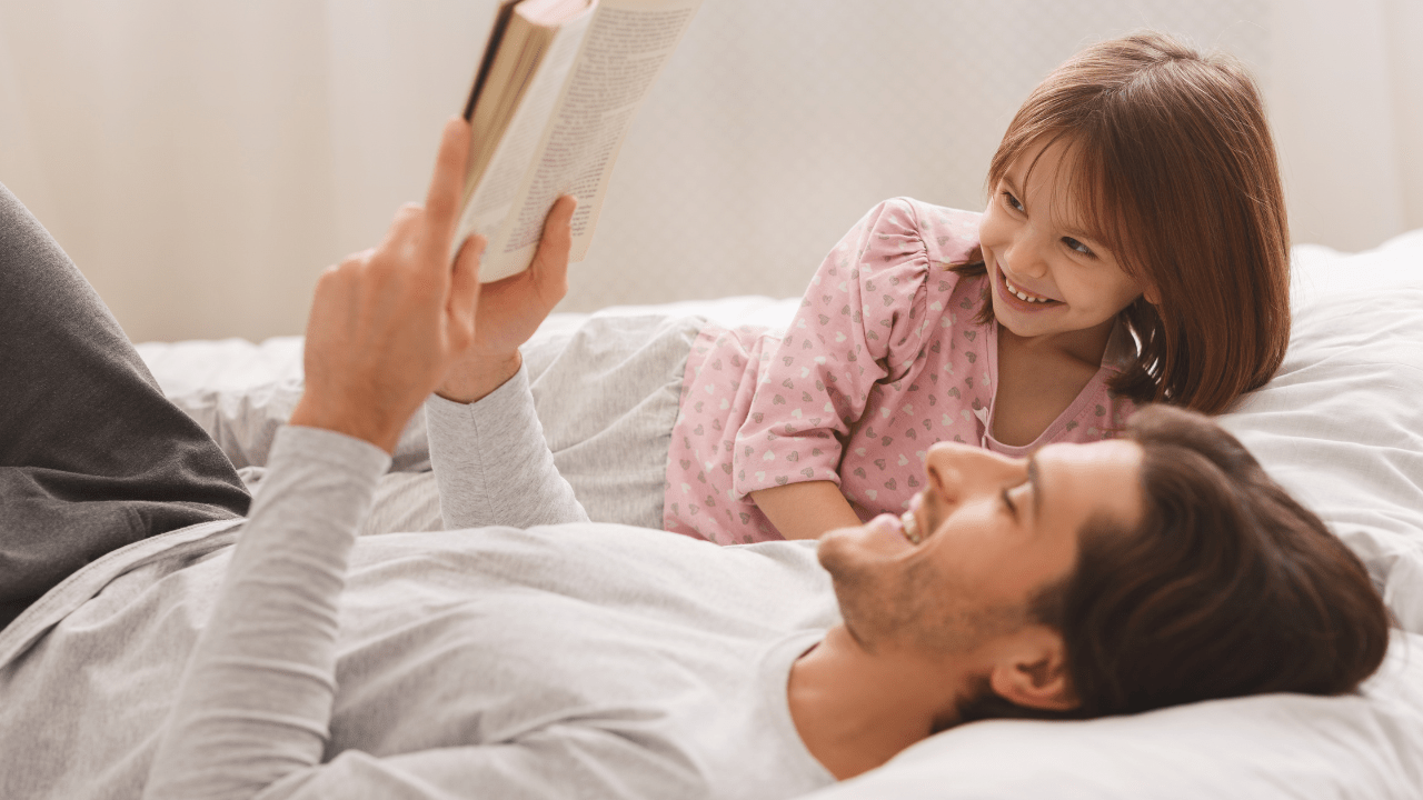 papá leyendo con su hija en la cama